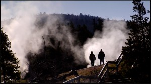 Visitors walk along steamy geyser basins in Yellowstone National Park